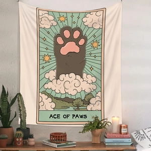 Detail of tarot style cat paw tapestry hanging on a white wall with home decor