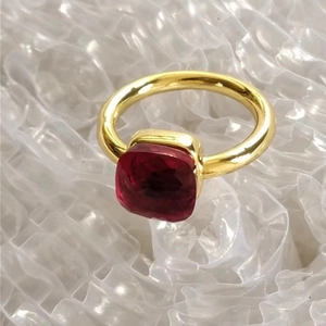 Detailed close-up of a golden stainless steel ring featuring a red square-cut zircon stone