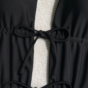 Detailed macro view of the black swimsuit drawstring with a neat bow tie and ruched fabric