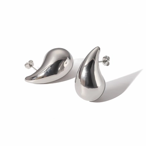 Detailed macro view of polished silver-colored water drop earrings with smooth finish