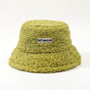 Detail of lime green sherpa bucket hat featuring a textured curly fleece and logo patch