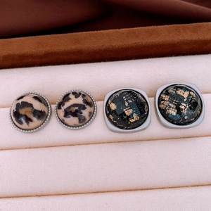 Gros plan sur boucles d'oreilles léopard en acrylique et clous en résine avec feuille d'or