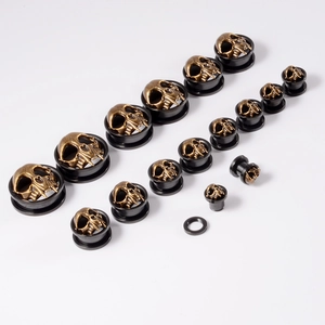 Detailed collection of skull ear gauges in various sizes with bronze finish on black base