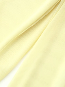 Macro shot of light yellow flowing mesh fabric showing delicate texture and pleats