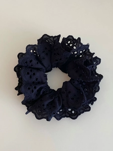 Détail du chouchou en dentelle noire double couche montrant la texture de broderie ajourée