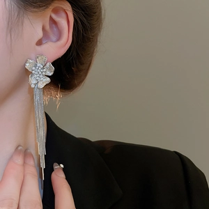 Macro shot of elegant silver flower earrings with long fringe tassels and pearl details