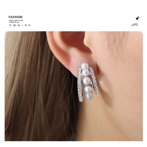 Détail de la boucle d'oreille en acier titane en forme de C avec perles et zircons brillants