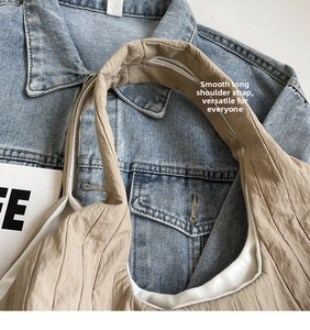 Nahaufnahme der khakifarbenen Schultertasche mit Faltenstruktur und glatten Riemen