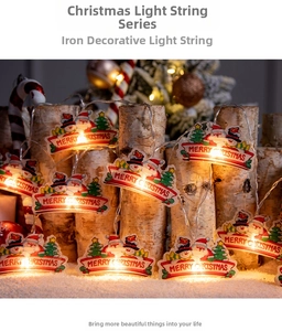 Détail de guirlande LED de Noël en métal avec Père Noël sur un socle en bois enneigé
