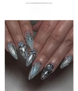 Detail view of Y2K silver 3D chrome butterfly and pearl charms on grey almond press-on nails