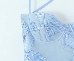 Détail de la robe bleu clair montrant le tissu mesh et les fleurs en satin 3D brodées