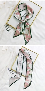 Close-up of pink floral twilly scarf with Be You text and green border on silk fabric