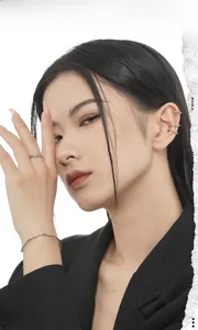 Detail of irregular texture silver bracelet and stacked ear cuff on model