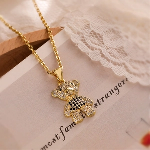Macro shot of gold-plated teddy bear necklace with blue checkered pattern and zircon stones