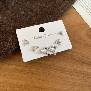 Détail de boucles d'oreilles feuille de ginkgo argentées avec perles et cristaux