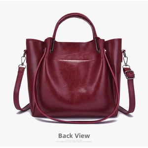 Back view of wine red synthetic leather handbag with adjustable strap and metallic hooks