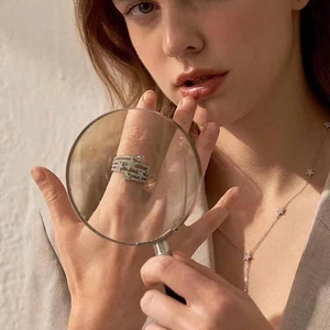 Multi-layer star ring with sparkling zircons shown through a magnifying glass detail