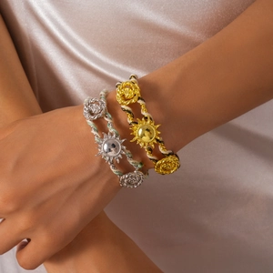 Woven cuff bracelet with metallic sunflower and rose charms in gold and silver finish