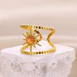 Macro shot of double-row gold bead ring with sunburst orange cat-eye stone detail
