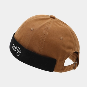 Détail de la boucle en métal et broderie Hello sur le bonnet docker en coton bicolore