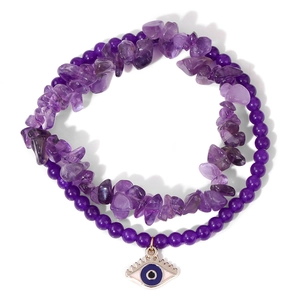 Macro detail of natural amethyst stones and evil eye charm on the purple beaded bracelet