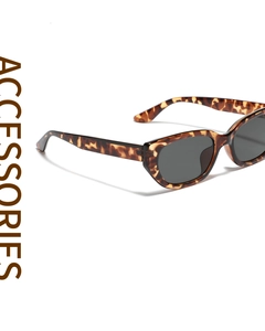Close-up of retro cat-eye sunglasses featuring tortoiseshell texture and dark grey lenses