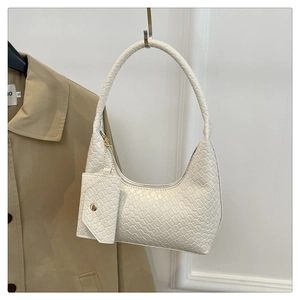 Detailed texture of white woven leather shoulder bag with matching chain coin purse