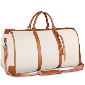 Detail of travel duffel bag showing soft beige PU leather and brown tassel zipper charm