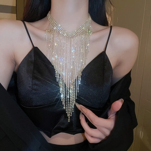 Detailed view of luxury V-shaped gold necklace with sparkling rhinestone tassels