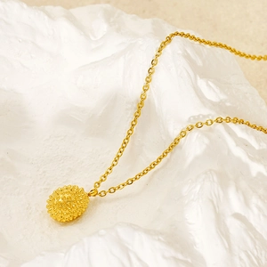 Chic gold stainless steel necklace with realistic durian pendant on white textured background