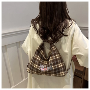 Detail of checkered tote bag featuring a cute dachshund embroidery and soft fabric texture