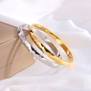 Macro shot of 18k gold and silver plated titanium steel bracelets with geometric textures