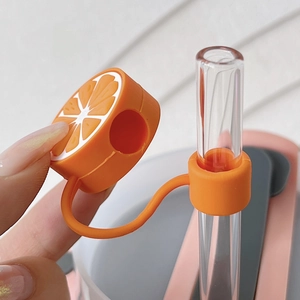 Detailed view of orange slice silicone straw cover protector cap on glass straw