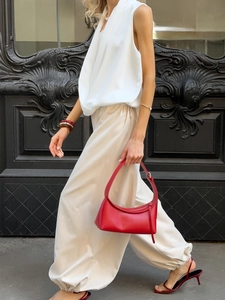 Street style view of beige cotton wide-leg trousers with elastic waist and red accessories