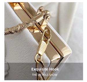 Macro shot of gold metal frame and hardware on white lychee grain leather bag