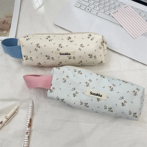 Detailed view of floral canvas pencil cases with Sozakka brand label and zippers