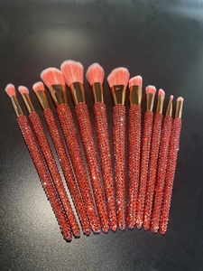 Detailed view of red rhinestone handles and rose gold ferrules on 12pcs makeup brush set