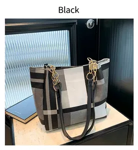 Dettaglio della borsa tote a scacchi capiente con eleganti manici a catena d'oro