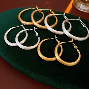 Minimalist geometric round hoop earrings in matte gold and silver finish for women
