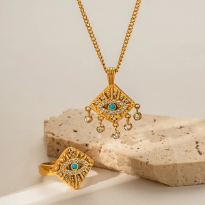 Détail de la bague et du collier en or 18 carats avec pierre verte et zircon sur pierre
