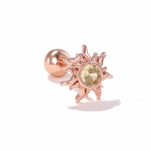 Detail of rose gold sun-shaped stud earring with a central yellow zircon gemstone