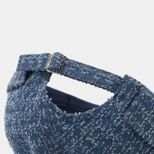 Detail of distressed denim docker hat showing adjustable strap and silver metal buckle