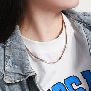 Rose gold snake bone chain necklace styled with a white T-shirt and denim jacket for daily wear