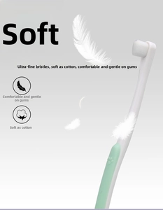Detail view of pet toothbrush with soft bristles and cute cat paw embossed handle