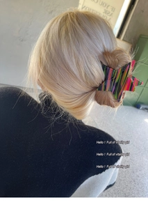 Detailed back view of a colorful star-shaped hair claw clip on blonde hair