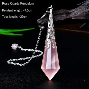 Macro view of rose quartz pendulum with silver metal clasp on dark wood background
