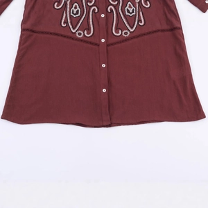 Camicia rosso scuro a maniche lunghe con ricamo fine sul petto e bottoni bianchi a vista