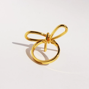 Elegant gold metal bow ring with minimalist knot design and polished glossy finish