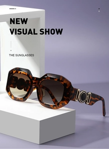 Detail of tortoiseshell sunglasses with thick geometric frames and gold ring temple accents