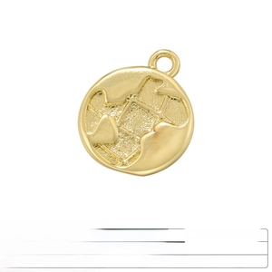 Close-up of golden round brass pendant with engraved geographic map pattern